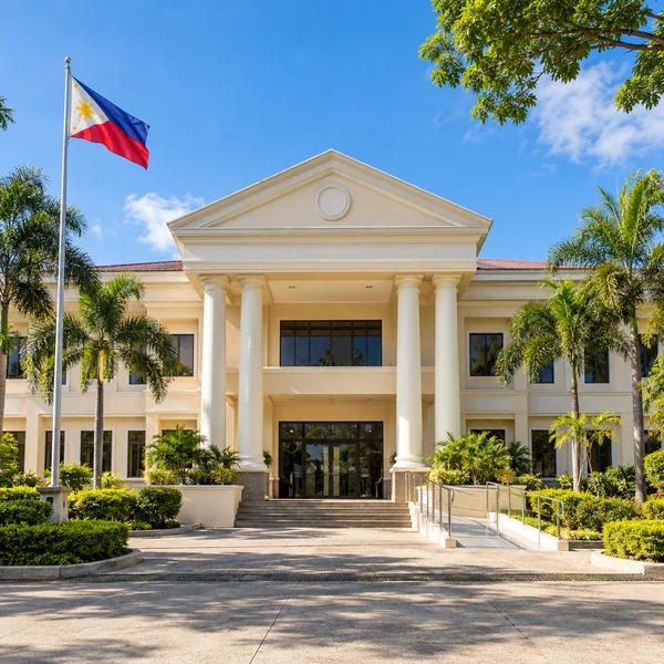 Illustrative Philippine municipal hall with an accessible entrance and Philippine flag